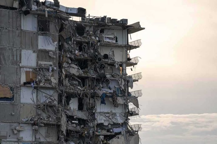 Partially collapsed apartment building with exposed rooms and debris