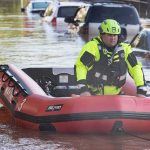 Hoosier Towns Drown—Evacuations Ignite Rescue worker in an inflatable boat during urban flooding