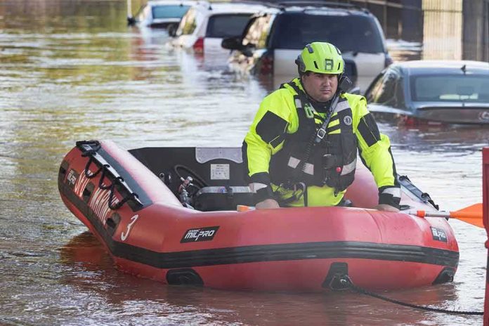 shutterstock_2035377782 Rescue worker in an inflatable boat during urban flooding