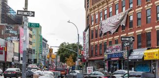 Street corner with piled garbage bags and traffic near brick storefronts
