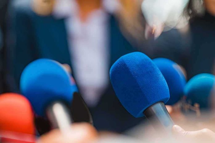 shutterstock_2166827697 Microphones clustered at a press event