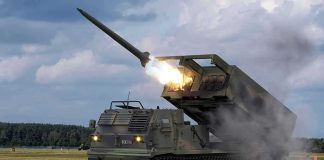 tracked rocket launcher firing missile on open field