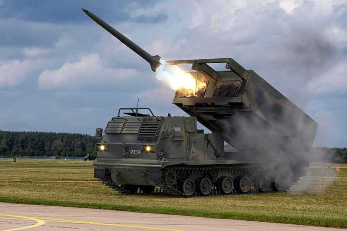 shutterstock_2192947265 tracked rocket launcher firing missile on open field