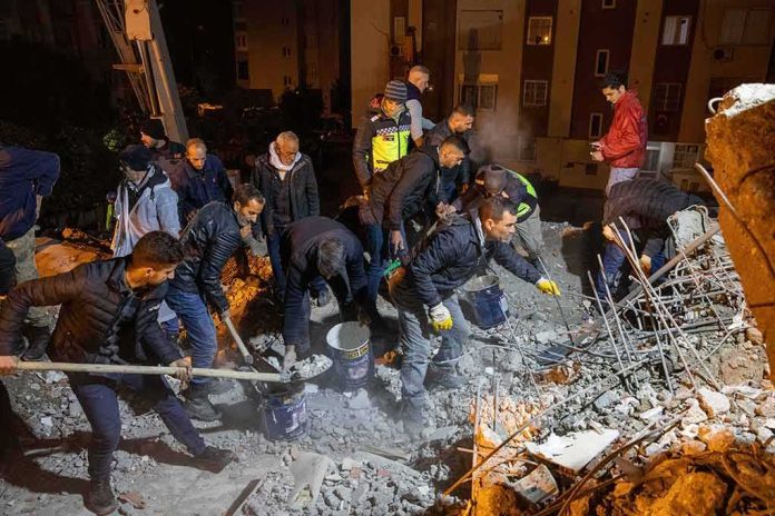 Rescue workers dig through rubble at night