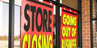 Storefront windows with bright closing sale signs