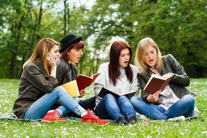 shutterstock_274705304-1 Group of young women reading books on grass in a park