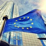 Tariff Ultimatum Works—What Did Europe Give? European Union flag waving in front of modern glass office buildings