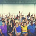 A’s No More: Harvard’s Shocking Grade Overhaul Group of people raising hands in an indoor audience