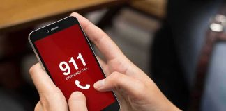 Hands holding a smartphone with a 911 emergency call screen