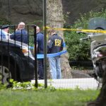 FBI Nabs Alleged White House Hit Squad law enforcement officers gather at taped-off outdoor scene
