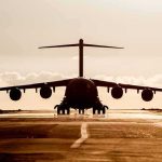 Large cargo aircraft on runway at sunrise