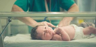 Shocking Child Euthanasia Ruling Sparks Uproar Newborn baby in hospital bassinet being cared for by nurse