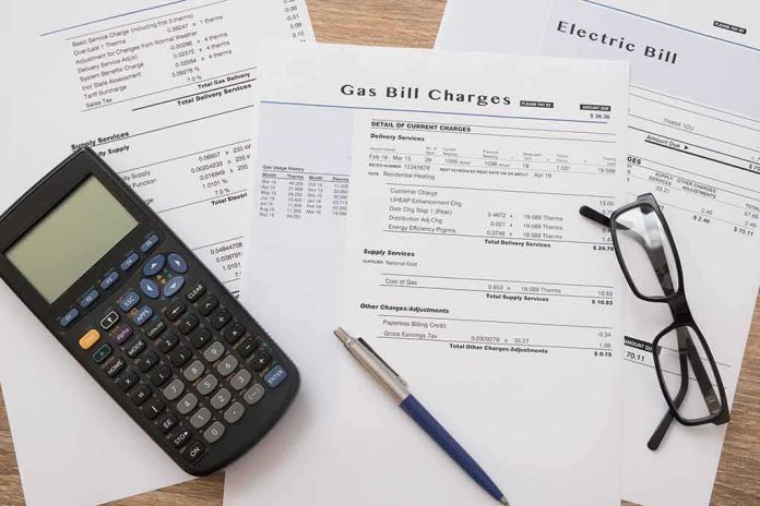 shutterstock_523849567 Utility bills with calculator, pen, and eyeglasses on a desk