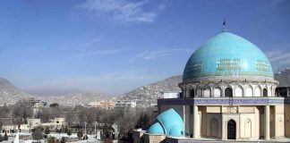 Blue-domed mosque with mountains in the background
