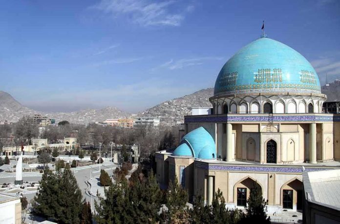 Blue-domed mosque with mountains in the background