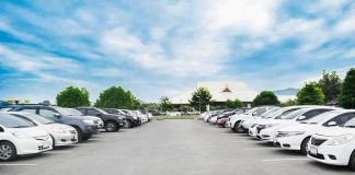 Parking lot lined with cars under a blue sky