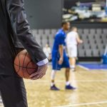 Wizards Meltdown Ends Trump Aide’s Career Basketball coach in suit holding ball courtside