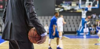 Wizards Meltdown Ends Trump Aide’s Career Basketball coach in suit holding ball courtside