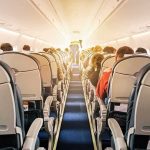 Airline Chaos: Actress Detained After Bloody Bite airplane cabin with passengers seated in economy class