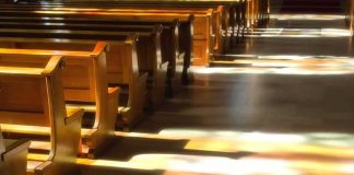 Rap Praising Killers inside Church – Locked Wooden church pews with stained glass light on the aisle