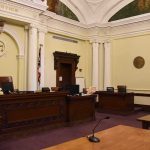 Feds Trace $55M Hack To Trading Cards empty courtroom with judge's bench and columns
