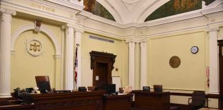 Feds Trace $55M Hack To Trading Cards empty courtroom with judge's bench and columns