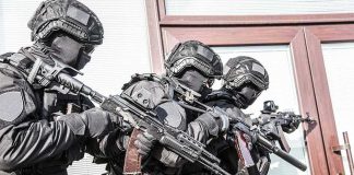 Wheelchair User Opens Fire on SWAT Tactical officers in black gear stack up with rifles by a building