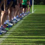 Runners lined up at a starting line on grass