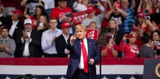 Praise Without Endorsement Sparks Buzz Donald Trump points from a rally stage; Rudi Koertzen and Bear Pascoe are in the crowd