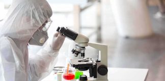 Old Rule Shattered: A Green Star Appears Scientist in protective gear using a microscope at a lab bench