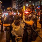 Bus Stop Street Chaos – 15-Year-Old Did WHAT? Police officers detain a protester at night on a city street