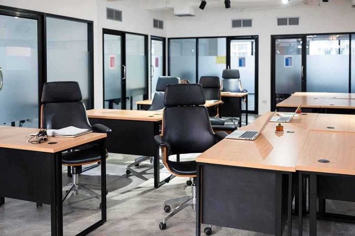 shutterstock_1784793092 Modern open office with empty desks and black chairs