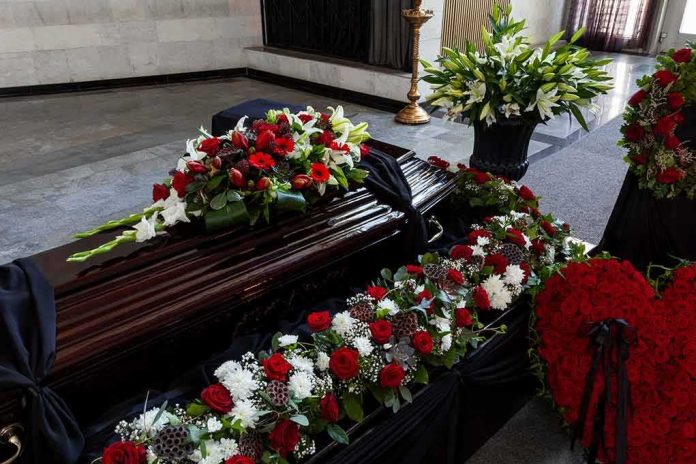 shutterstock_1869583603 Coffin with floral arrangements at a funeral service
