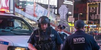 Fifth Avenue Stabbing Sparks Hate-Crime Probe Police officers in tactical gear near a patrol vehicle at night