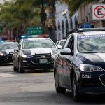police cars with flashing lights drive down a city street