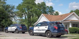 Texas Mother Arrested After Both Sons Die Two police SUVs parked near a suburban house