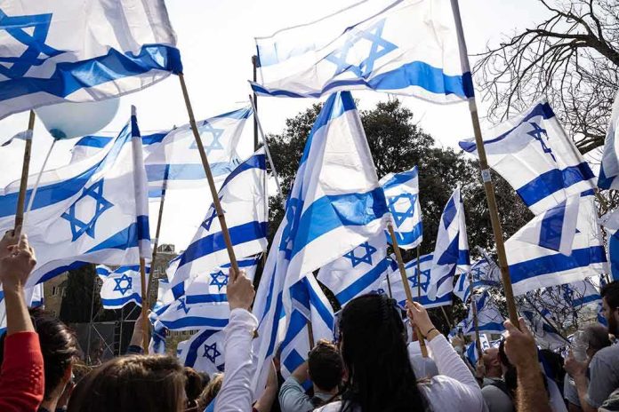 Crowd waving Israeli flags outdoors