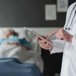 Ric Flair Bleeds, ER Dash After Clot Reveal Doctor using tablet beside hospital patient