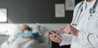 Ric Flair Bleeds, ER Dash After Clot Reveal Doctor using tablet beside hospital patient