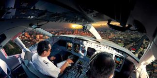 Flight Plunge Triggers Chilling Questions Pilots in an airplane cockpit during city approach at sunset
