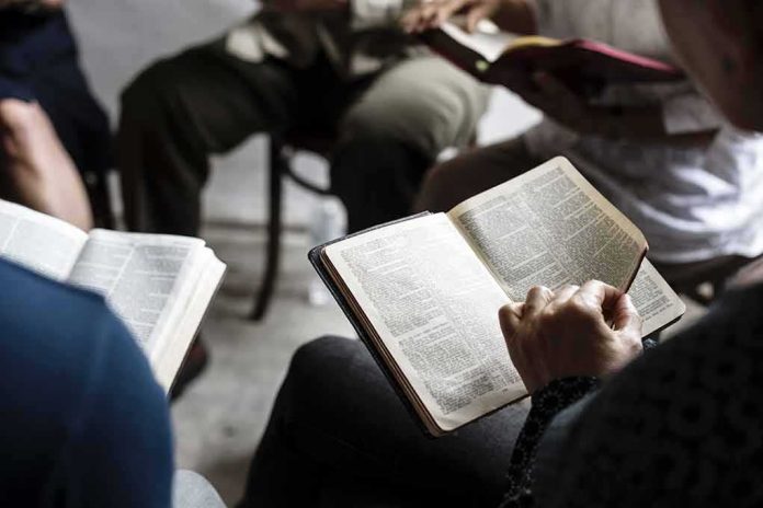 Hands holding open books in a small discussion circle
