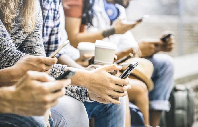 shutterstock_794117806 Group of people sitting and using smartphones