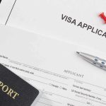 Visa application form with passport and pen